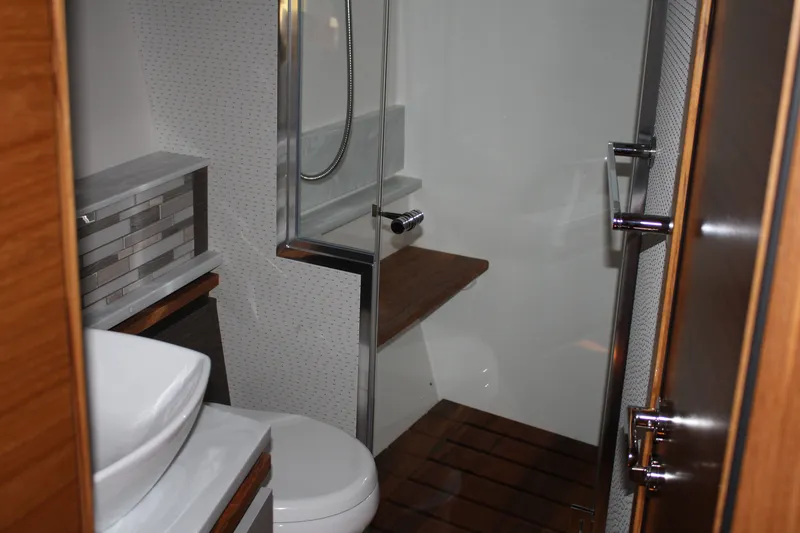 Slide: The Image of Luxurious bathroom in 2020 Tiara Yachts C49 Coupe with modern fixtures and wooden accents. - 54