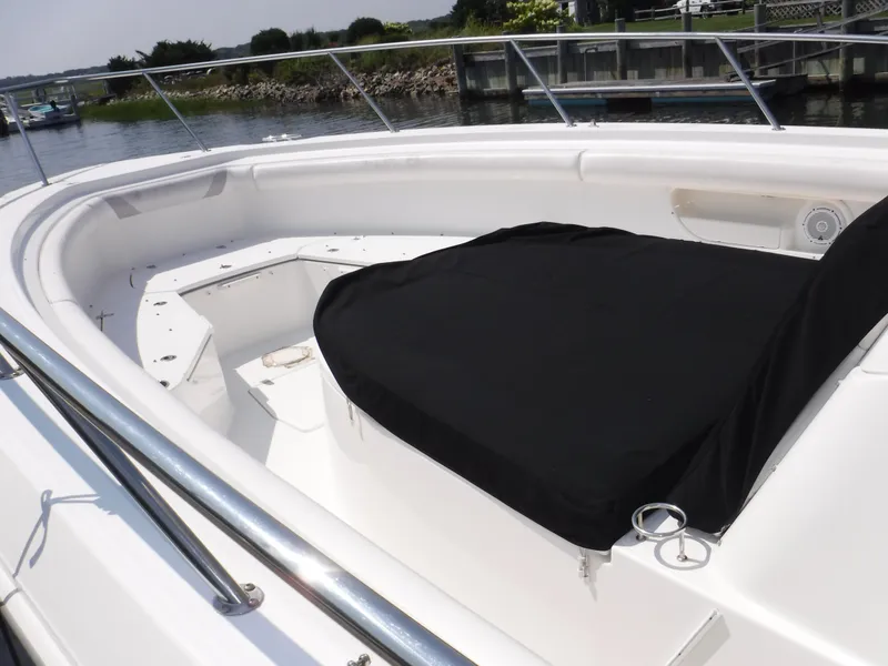 Slide: The Image of 2014 Boston Whaler 370 Outrage boat with covered seating area, docked by the water. - 19