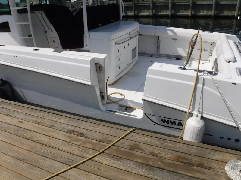 Slide: The Image of 2014 Boston Whaler 370 Outrage docked, showcasing spacious deck and seating area. - 22