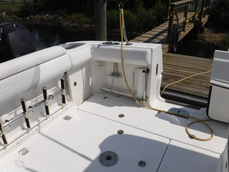 Slide: The Image of 2014 Boston Whaler 370 Outrage boat deck with fishing rod holders and dock view. - 24