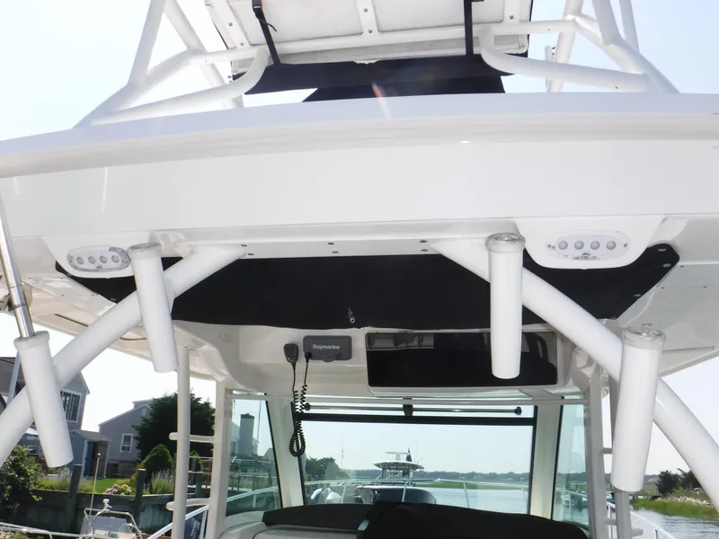 Slide: The Image of 2014 Boston Whaler 370 Outrage boat with rod holders and electronics, docked in a marina. - 26