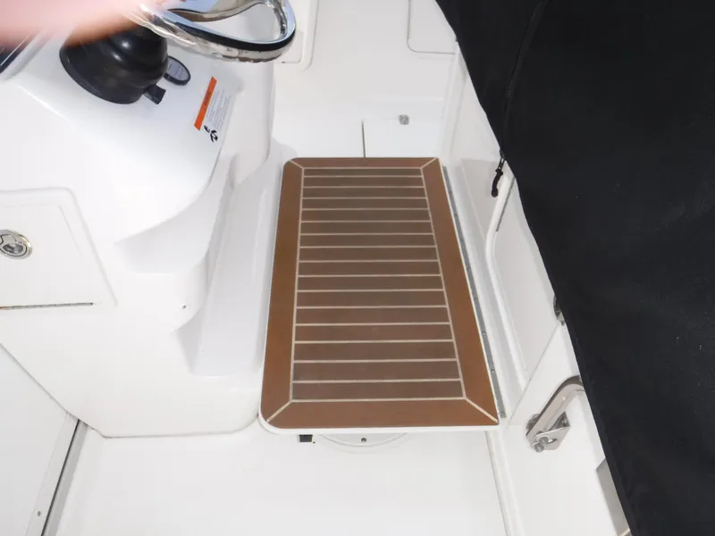 Slide: The Image of 2014 Boston Whaler 370 Outrage helm area with wooden footrest and steering wheel. - 32