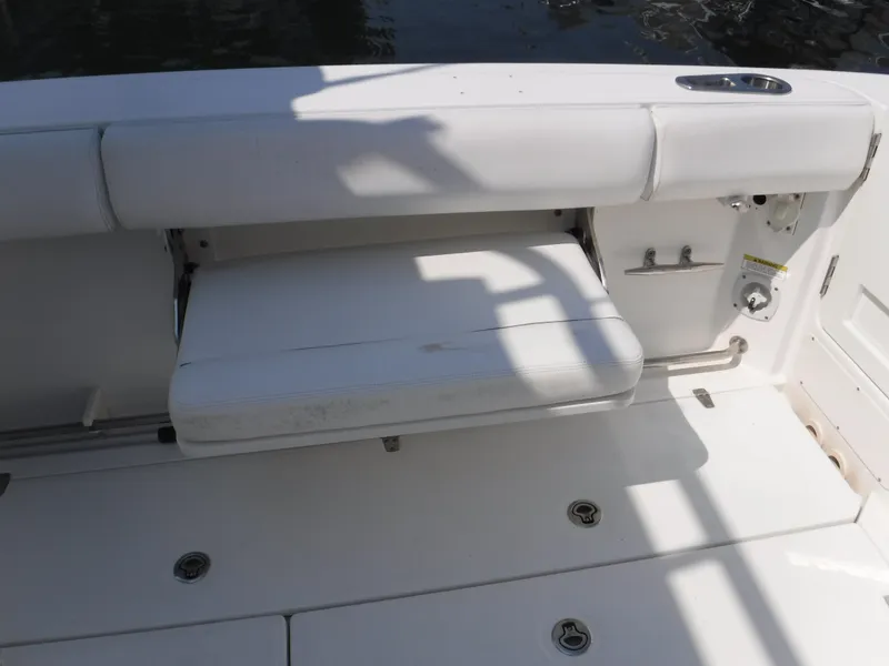 Slide: The Image of 2014 Boston Whaler 370 Outrage boat seating area with white cushioned bench. - 35