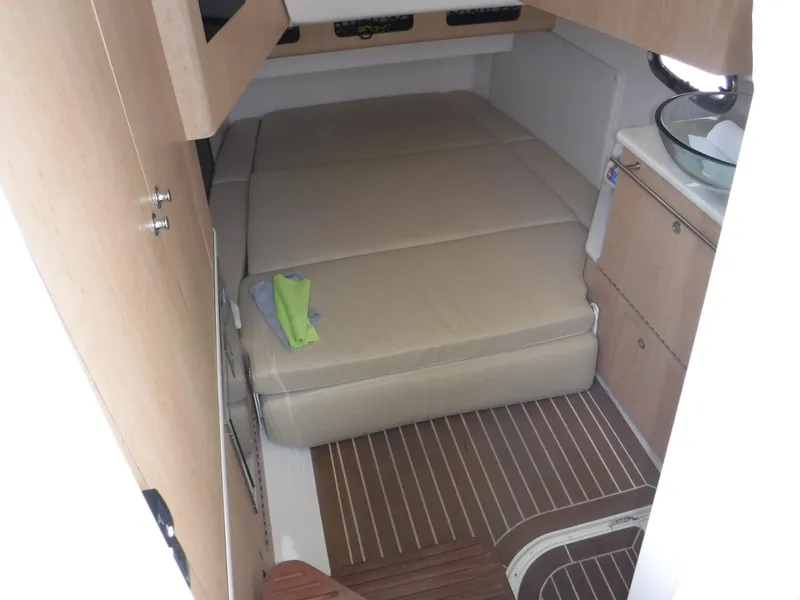 Slide: The Image of 2014 Boston Whaler 370 Outrage cabin interior with bed and wooden flooring. - 36