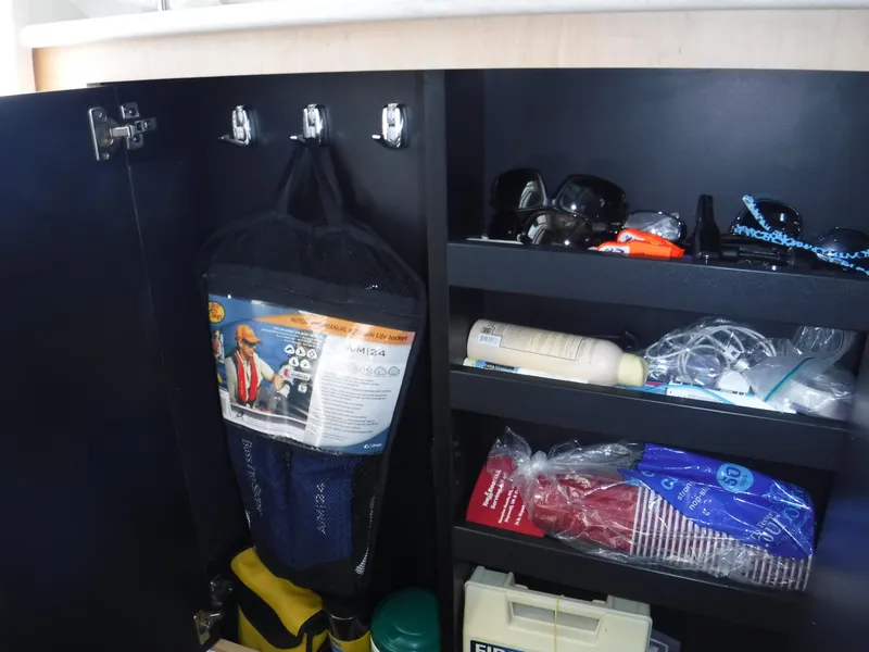 Slide: The Image of Storage cabinet on a 2014 Boston Whaler 370 Outrage, containing safety gear and accessories. - 37