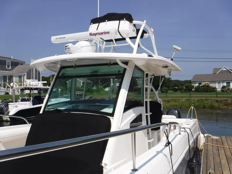 Slide: The Image of 2014 Boston Whaler 370 Outrage boat docked, featuring Raymarine equipment and sleek design. - 4