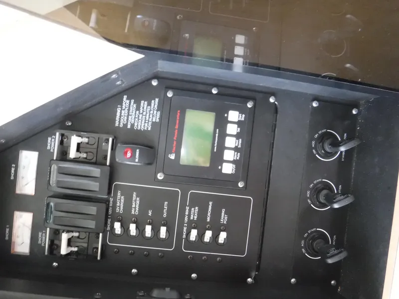 Slide: The Image of Control panel of a 2014 Boston Whaler 370 Outrage boat, featuring switches and display. - 40