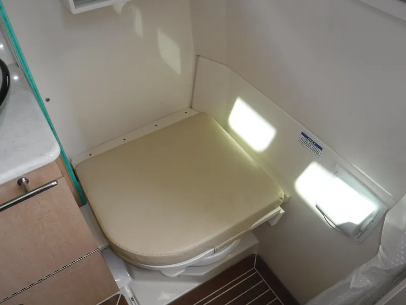 Slide: The Image of 2014 Boston Whaler 370 Outrage cabin interior with cushioned seat and wooden flooring. - 44