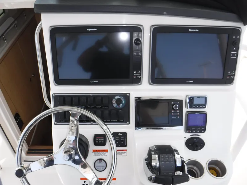 Slide: The Image of Control panel of 2014 Boston Whaler 370 Outrage with dual Raymarine displays and steering wheel. - 49