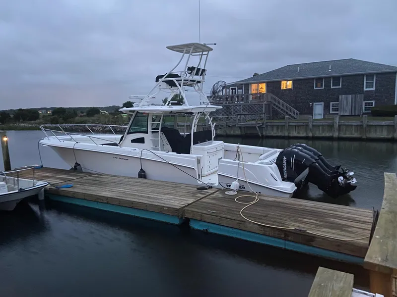 Slide: The Image of 2014 Boston Whaler 370 Outrage docked by a waterfront house at dusk. - 5