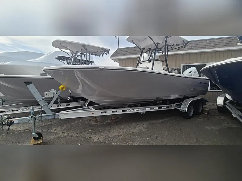 Slide: The Image of 2023 Sea Born LX22 Center Console boat on a trailer, parked outdoors. - 2