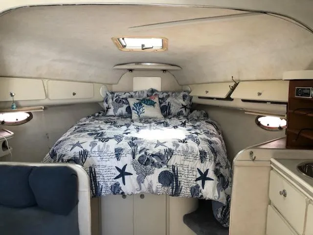 Slide: The Image of 1992 Baja 340 Motoryacht cabin with nautical-themed bedding and cozy interior design. - 10