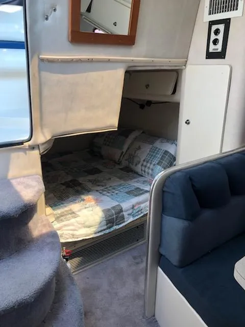 Slide: The Image of 1992 Baja 340 Motoryacht interior with cozy sleeping area and blue seating. - 11