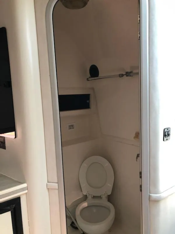 Slide: The Image of Bathroom interior of a 1992 Baja 340 Motoryacht, featuring a compact toilet setup. - 12
