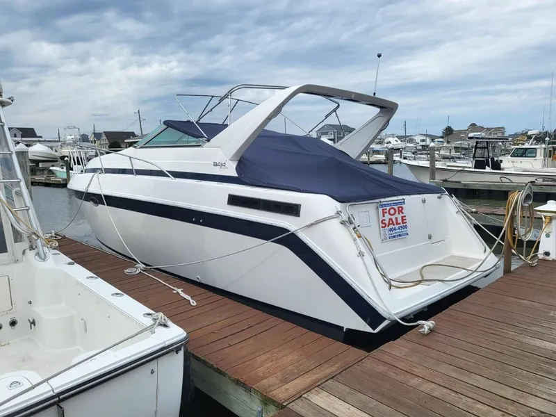 Slide: The Image of 1992 Baja 340 Motoryacht for sale, docked at marina, with blue cover. - 2