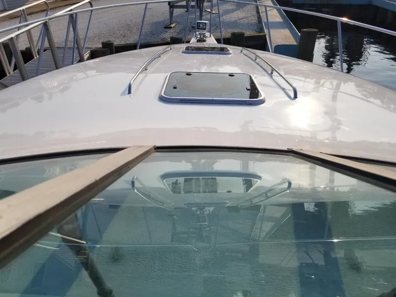 Slide: The Image of 1992 Baja 340 Motoryacht bow view with hatch and railing, docked at marina. - 21