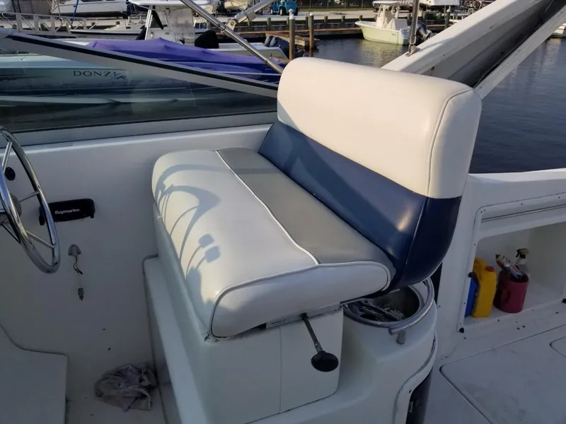 Slide: The Image of 1992 Baja 340 Motoryacht helm seat with blue and white upholstery, docked at marina. - 24