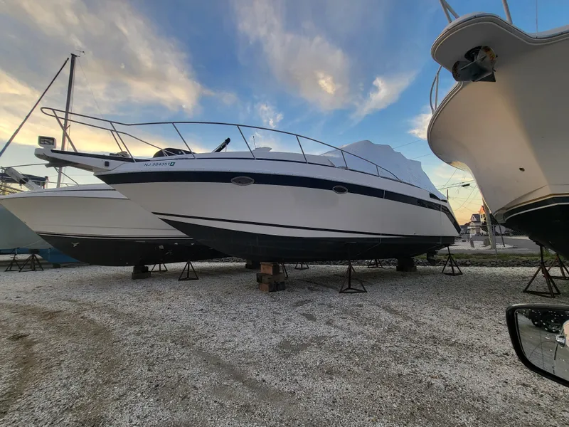 Slide: The Image of 1992 Baja 340 Motoryacht on stands, under a cloudy sky, in a boatyard. - 31