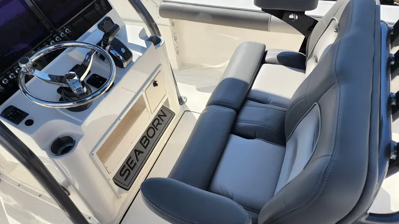 Slide: The Image of 2022 Sea Born LX24 Center Console boat interior with steering wheel and cushioned seats. - 15