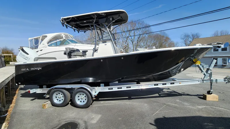 Slide: The Image of 2022 Sea Born LX24 Center Console boat on a trailer in a parking lot. - 2