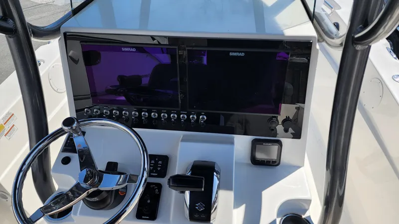 Slide: The Image of 2022 Sea Born LX24 Center Console boat dashboard with dual Simrad displays and steering wheel. - 6