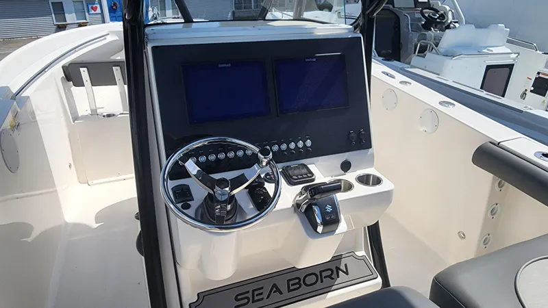 Slide: The Image of 2023 Sea Born SX239 Offshore boat dashboard with dual screens and steering wheel. - 26