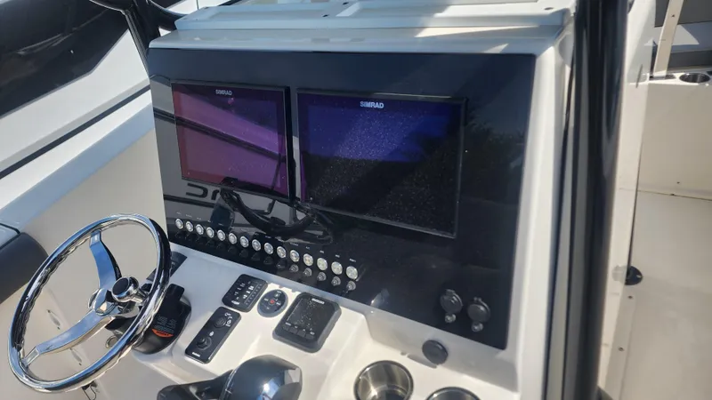 Slide: The Image of 2023 Sea Born SX239 Offshore boat dashboard with dual Simrad displays and steering wheel. - 39