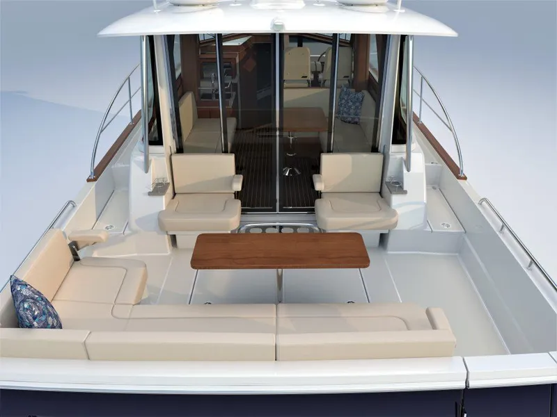 Slide: The Image of 2025 Sabre 43 Salon Express yacht with spacious outdoor seating area and wooden table. - 12