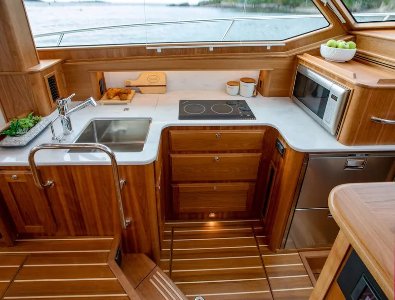 Slide: The Image of Modern kitchen in 2025 Sabre 43 Salon Express yacht with wood cabinetry and stainless steel appliances. - 24