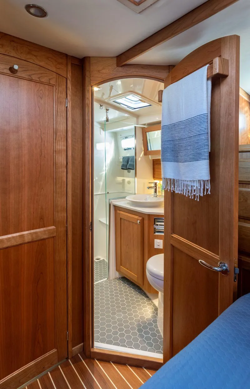 Slide: The Image of 2025 Sabre 43 Salon Express bathroom with wooden cabinetry and modern fixtures. - 30