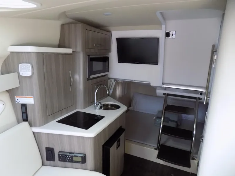 Slide: The Image of 2019 Regal 28 Express cabin interior with kitchenette, sink, and TV. - 10