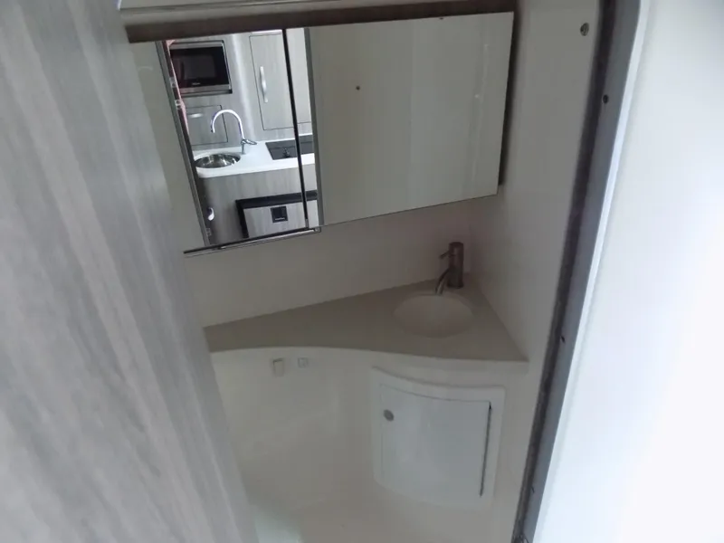 Slide: The Image of 2019 Regal 28 Express bathroom with sink, mirror, and compact design. - 13