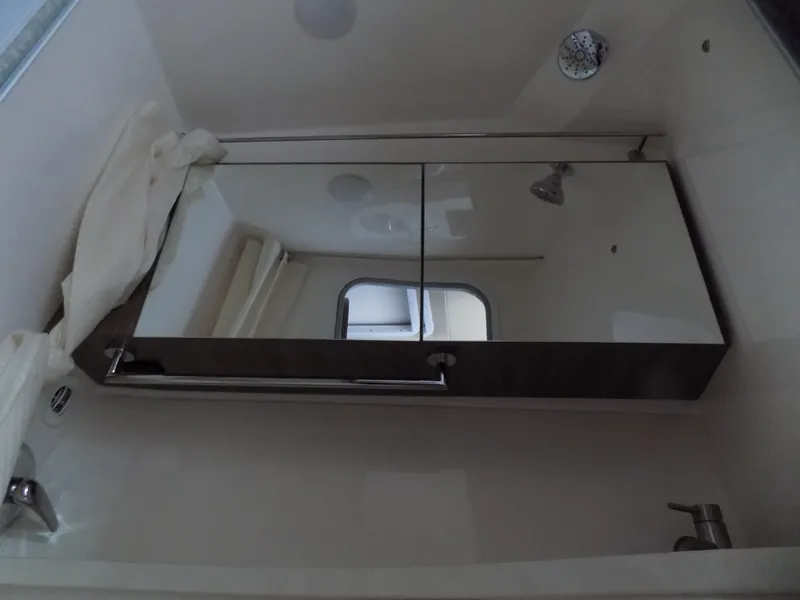 Slide: The Image of Bathroom interior of 2019 Regal 28 Express boat with mirror and showerhead. - 16