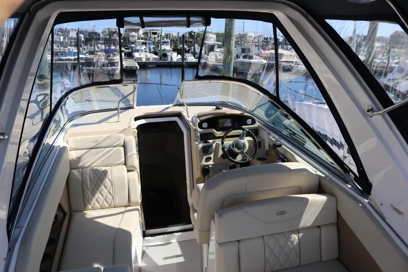 Slide: The Image of 2019 Regal 28 Express boat interior with luxurious seating and modern dashboard, docked at marina. - 21