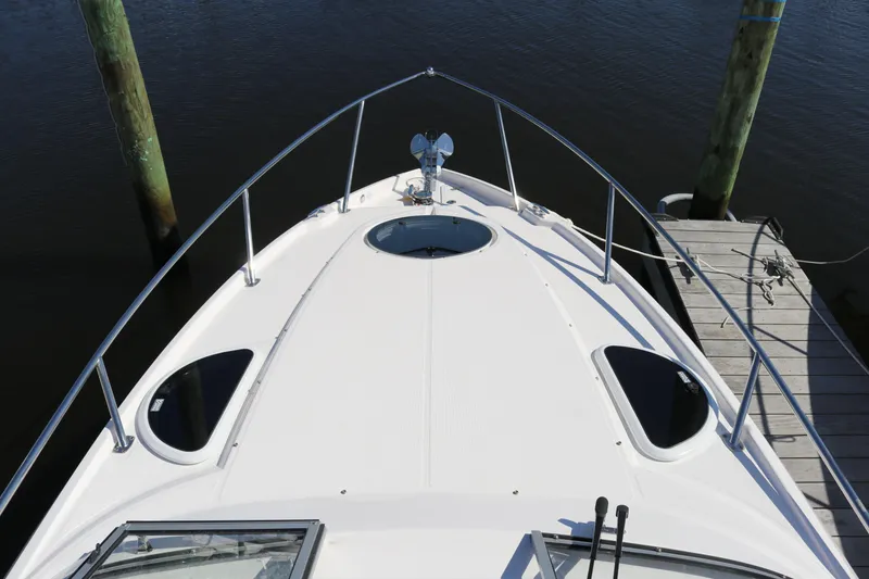 Slide: The Image of 2019 Regal 28 Express boat bow view at dock, featuring sleek design and railing. - 28