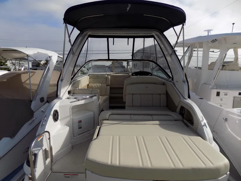 Slide: The Image of 2019 Regal 28 Express boat with beige seating and black canopy, docked in a marina. - 3