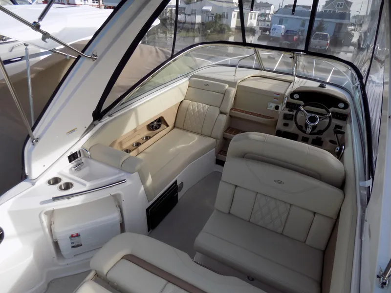 Slide: The Image of 2019 Regal 28 Express boat interior with beige seating and steering console. - 4