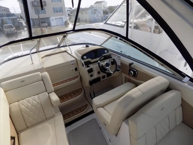 Slide: The Image of 2019 Regal 28 Express boat interior with beige seating and modern helm controls. - 5
