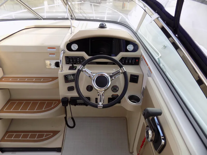 Slide: The Image of 2019 Regal 28 Express boat helm with steering wheel and control panel. - 7
