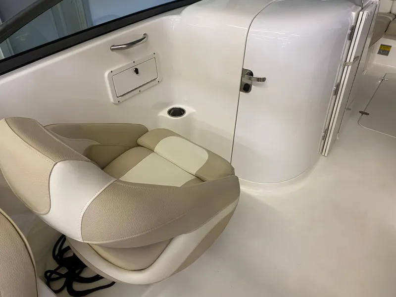 Slide: The Image of 2018 NauticStar 243DC Sport Deck interior with beige and white seating. - 11