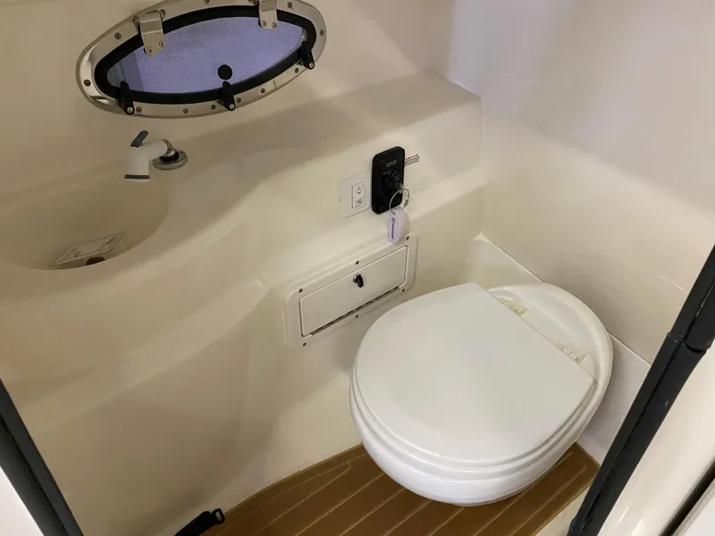 Slide: The Image of 2018 NauticStar 243DC Sport Deck boat bathroom with toilet and sink. - 12