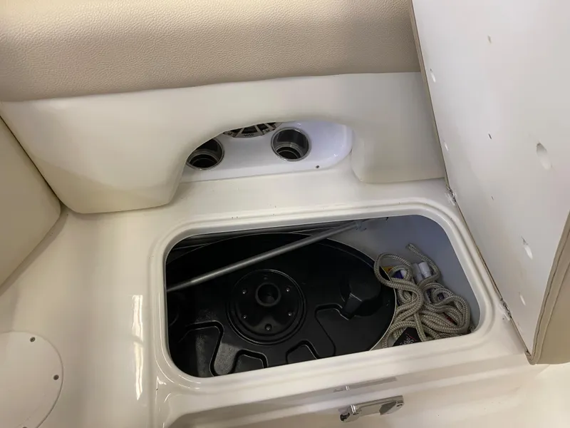 Slide: The Image of 2018 NauticStar 243DC Sport Deck storage compartment with ropes and equipment. - 18