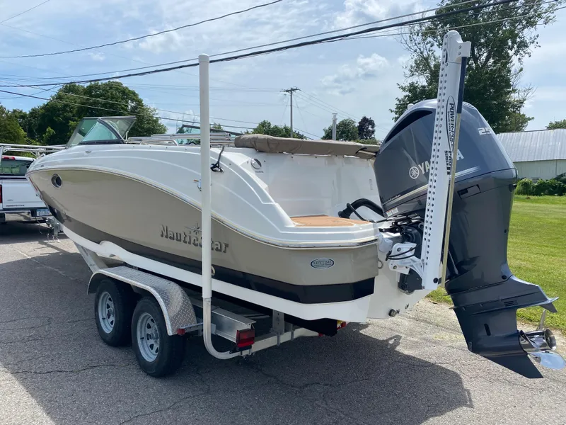 Slide: The Image of 2018 NauticStar 243DC Sport Deck boat on a trailer with Yamaha outboard motor. - 2