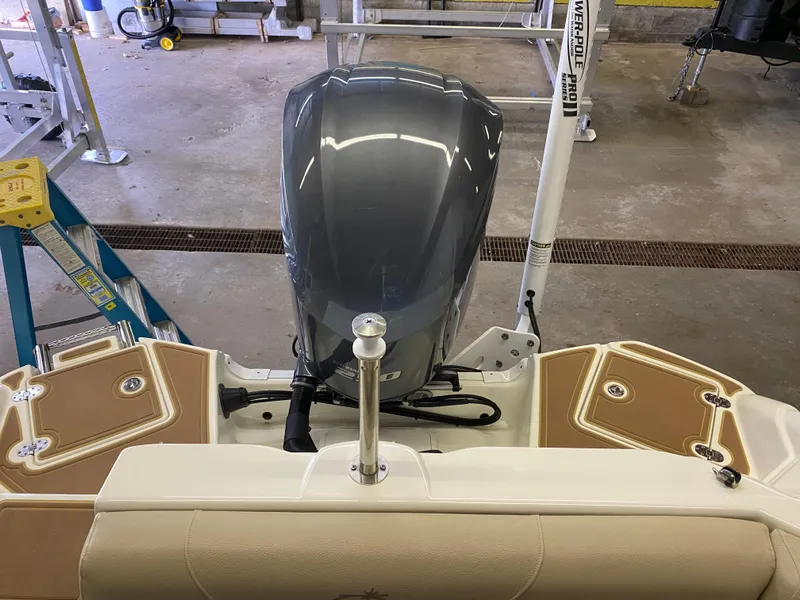 Slide: The Image of 2018 NauticStar 243DC Sport Deck boat with outboard motor in a garage. - 5