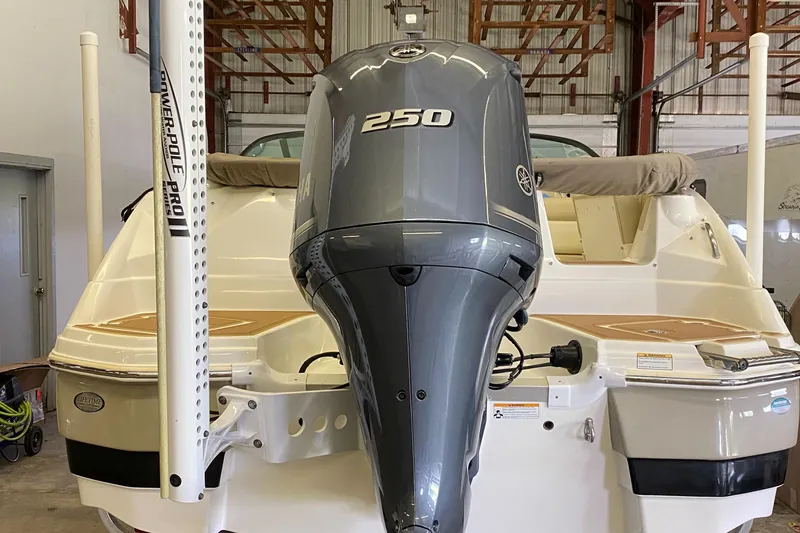 Slide: The Image of 2018 NauticStar 243DC Sport Deck boat with 250 HP engine in a warehouse. - 6