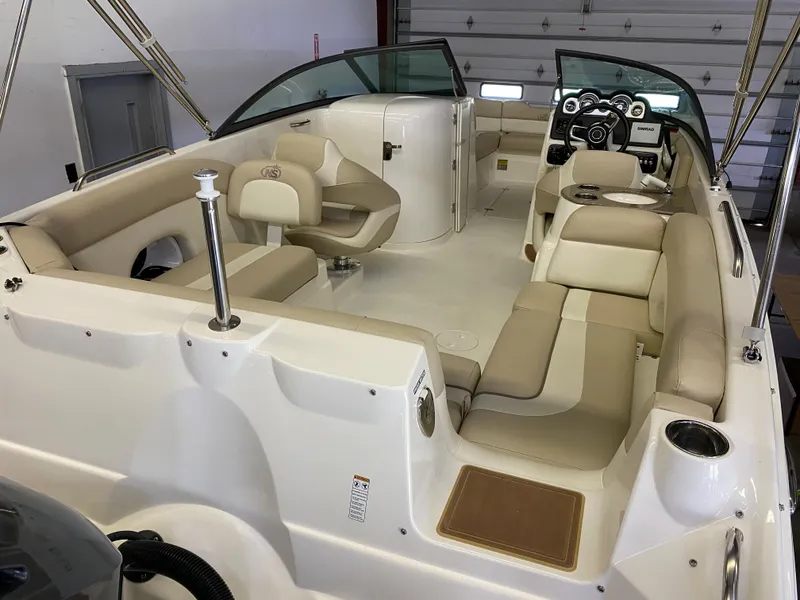 Slide: The Image of 2018 NauticStar 243DC Sport Deck boat interior with beige seating and modern dashboard. - 7
