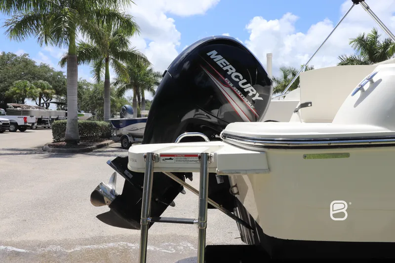 Slide: The Image of 2018 Bayliner 210 DB boat with Mercury outboard motor in sunny marina setting. - 8