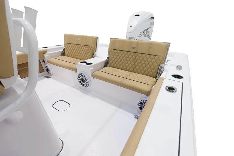 Slide: The Image of 2024 Sportsman Masters 267 Bay Boat interior with tan cushioned seating and white motor. - 18