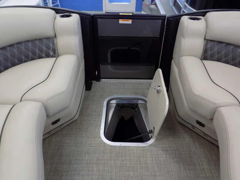 Slide: The Image of 2023 Barletta L23UC boat interior with open storage compartment and beige seating. - 17