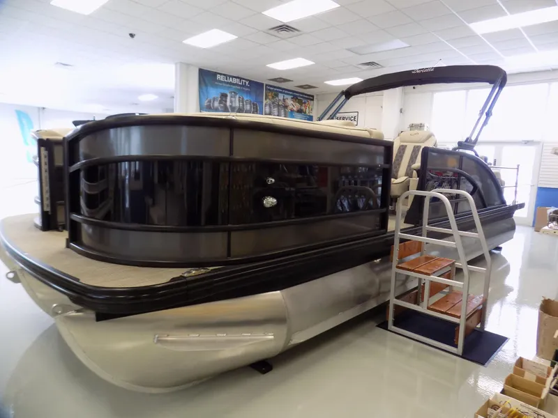 Slide: The Image of 2023 Barletta L23UC pontoon boat displayed indoors with sleek design and modern features. - 4